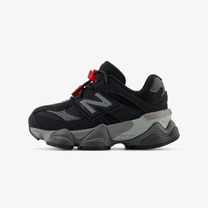 Zapatillas deportivas negras con acentos grises, con una parte superior texturizada, paneles de malla y cierre de cordón con toggle rojo. Suela gruesa y acolchada.