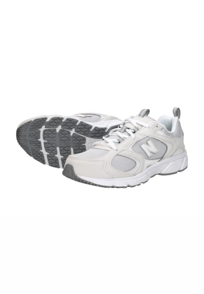 Par de zapatillas de correr New Balance en blanco y gris con paneles de malla, diseño con cordones y suelas de goma texturizadas, mostradas sobre un fondo blanco.