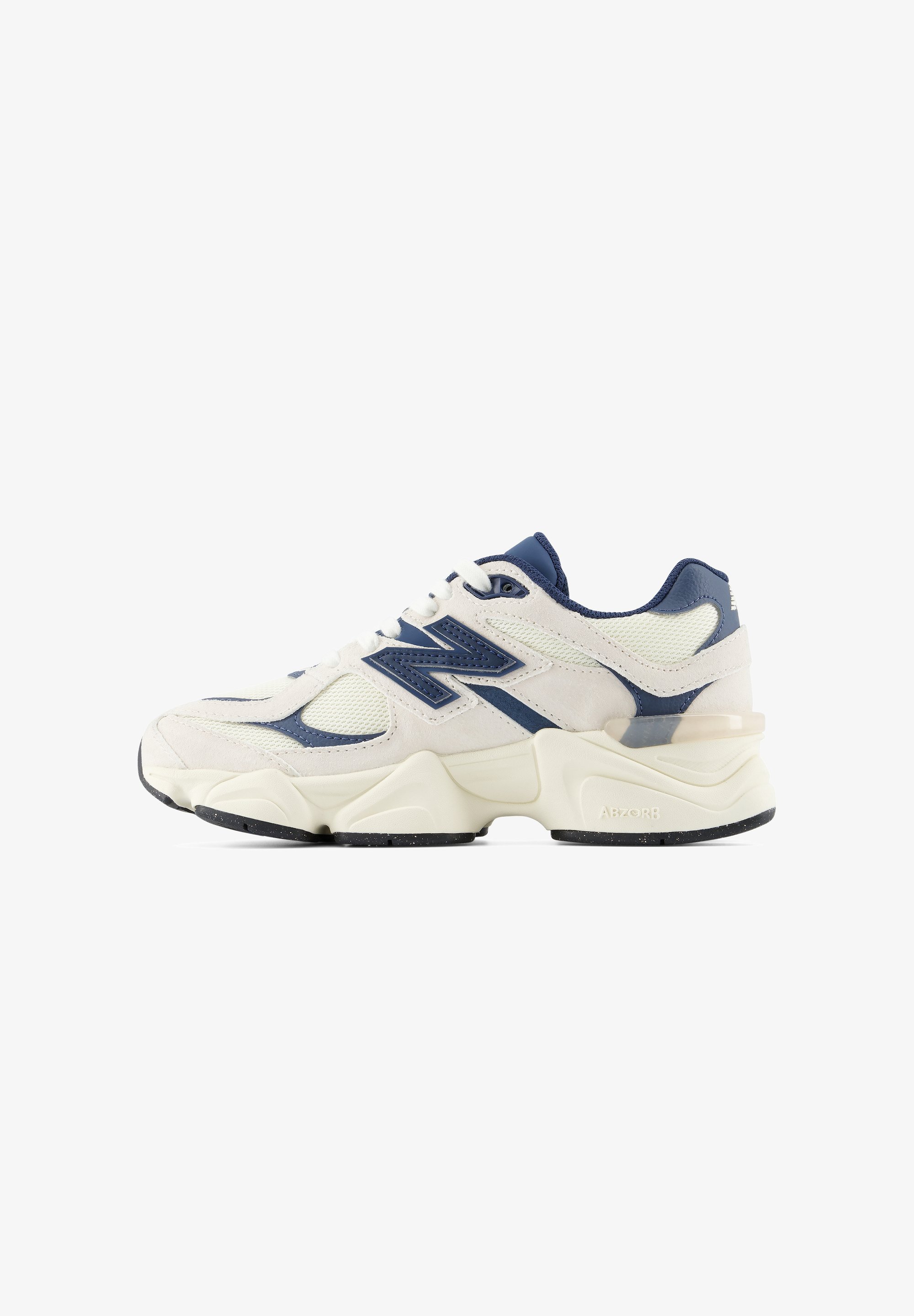 Zapatilla deportiva blanca y azul marino con suela gruesa, parte superior de malla y cuero, y gran logo "N" en el lateral, mostrada desde el lado externo.
