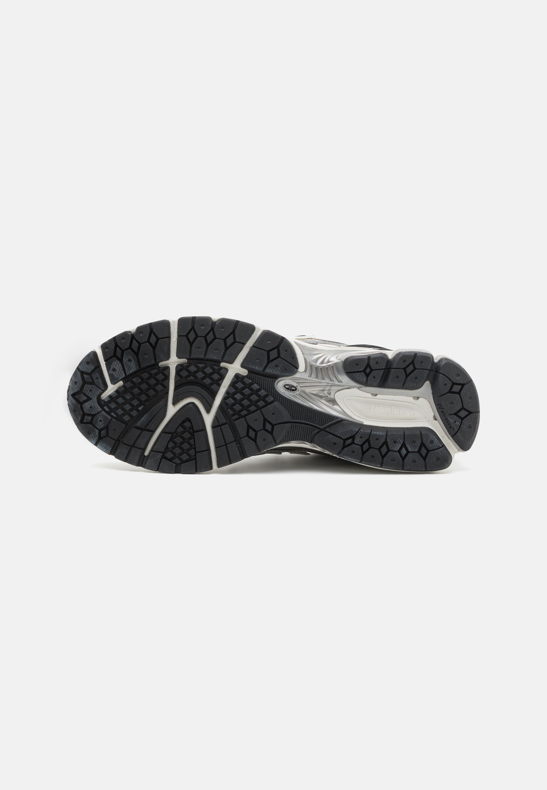 Suela de goma negra con patrones texturizados, silueta curvada y acentos en blanco y gris a lo largo del costado para mayor estabilidad y agarre.