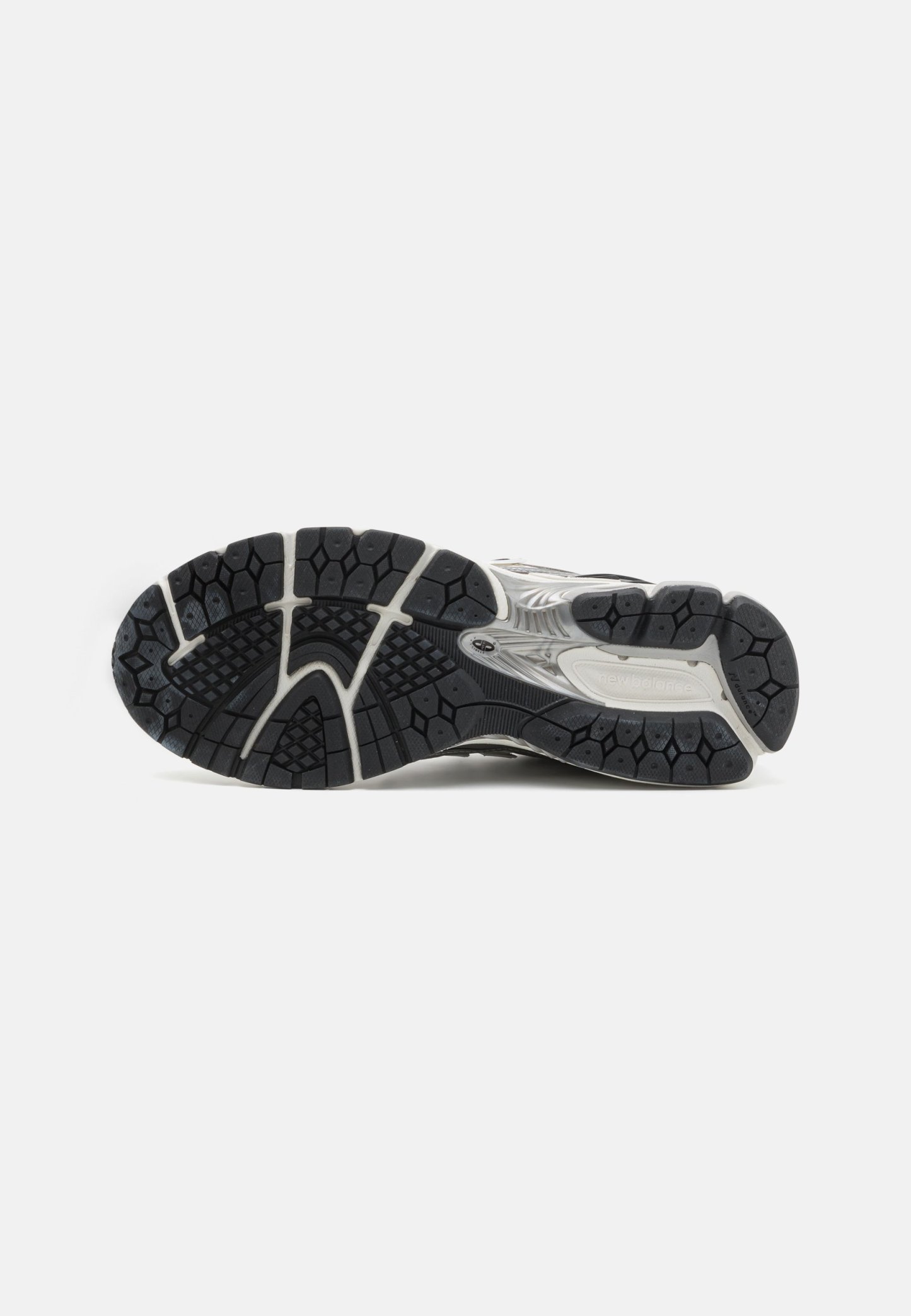 Suela de goma negra con patrones texturizados, silueta curvada y acentos en blanco y gris a lo largo del costado para mayor estabilidad y agarre.