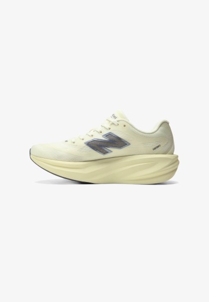 Zapatilla de correr New Balance color beige claro con suela gruesa y moldeada, logo lateral gris y cordones, vista desde el lado exterior.