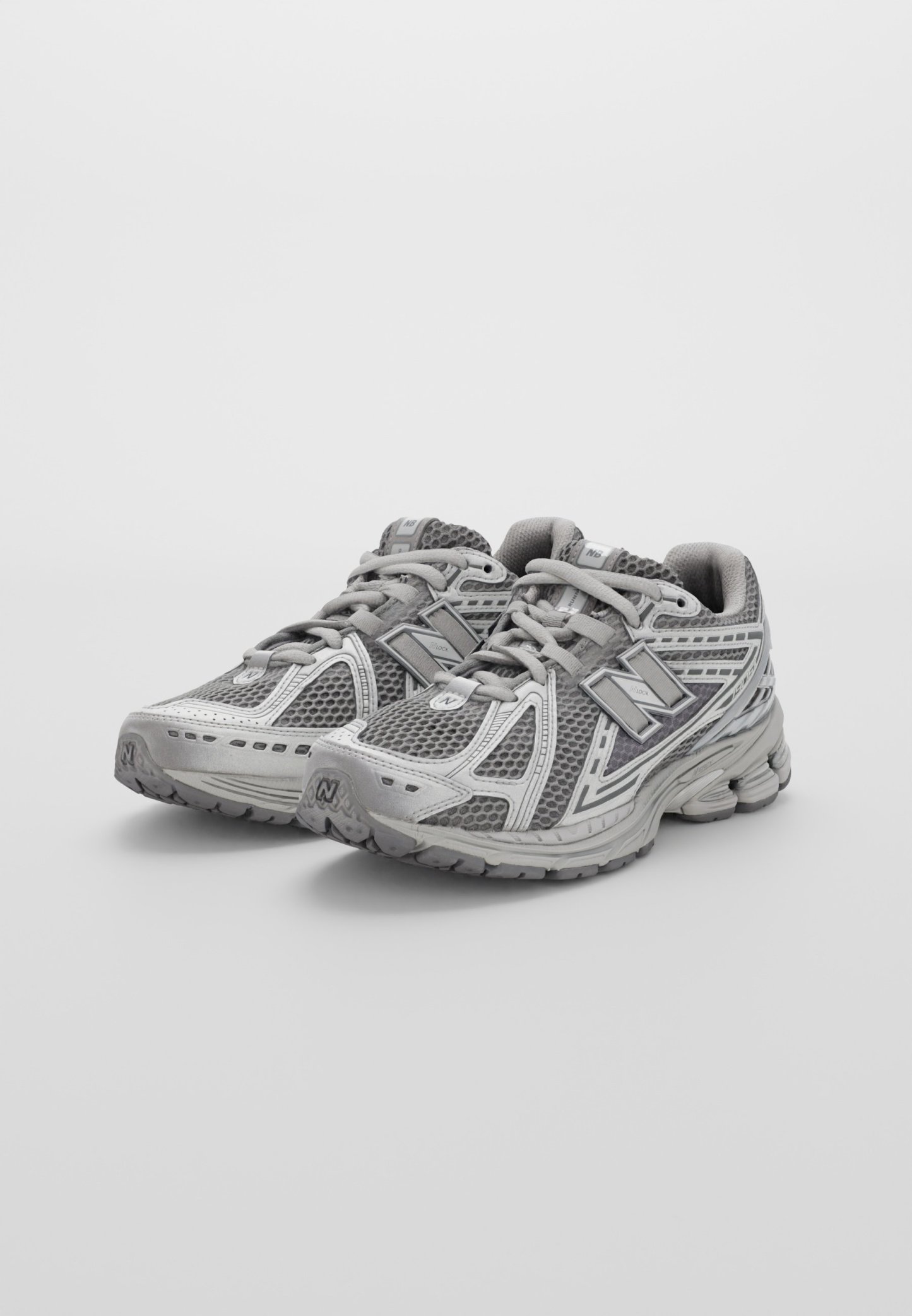 Zapatillas deportivas grises con parte superior de malla, puntera reforzada y suela texturizada. Con detalles reflectantes y cuello acolchado para mayor comodidad.