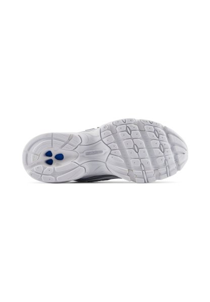 Suela de zapato deportivo blanco New Balance que muestra un patrón de agarre texturizado y insertos circulares azules cerca de la zona del talón.