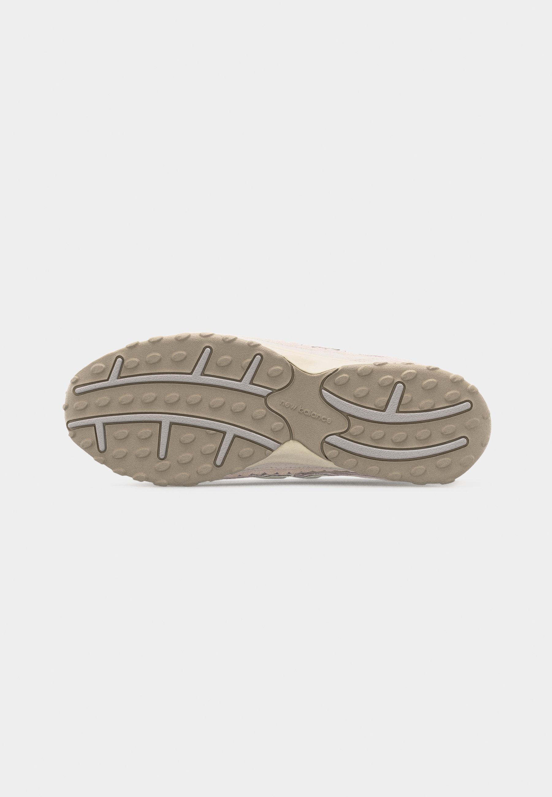 Suela de zapato con patrón de tracción beige que presenta agarres ovalados y lineales, y el logo "new balance" en relieve en el centro.