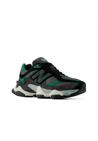 Zapatilla deportiva negra, gris y verde con paneles de malla, suela gruesa acolchada y un gran logotipo "N" en el lateral, mostrada en ángulo.