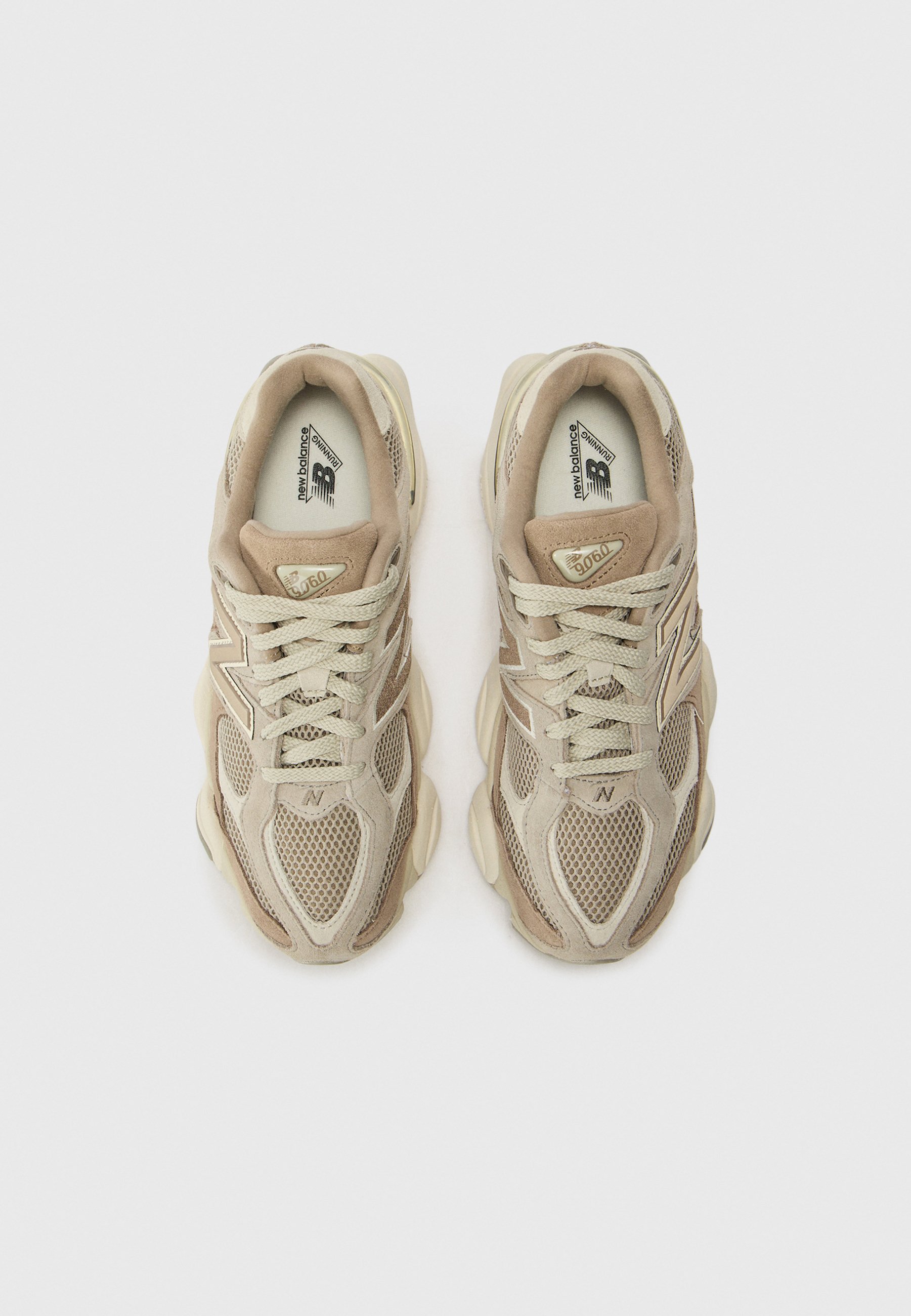 Zapatillas deportivas en color beige, fabricadas con materiales de malla y ante, con puntera redondeada, cierre con cordones y lengüeta acolchada. Presentan el logo en el lateral y en la lengüeta.
