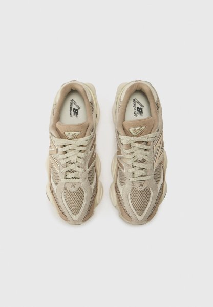 Zapatillas deportivas en color beige, fabricadas con materiales de malla y ante, con puntera redondeada, cierre con cordones y lengüeta acolchada. Presentan el logo en el lateral y en la lengüeta.