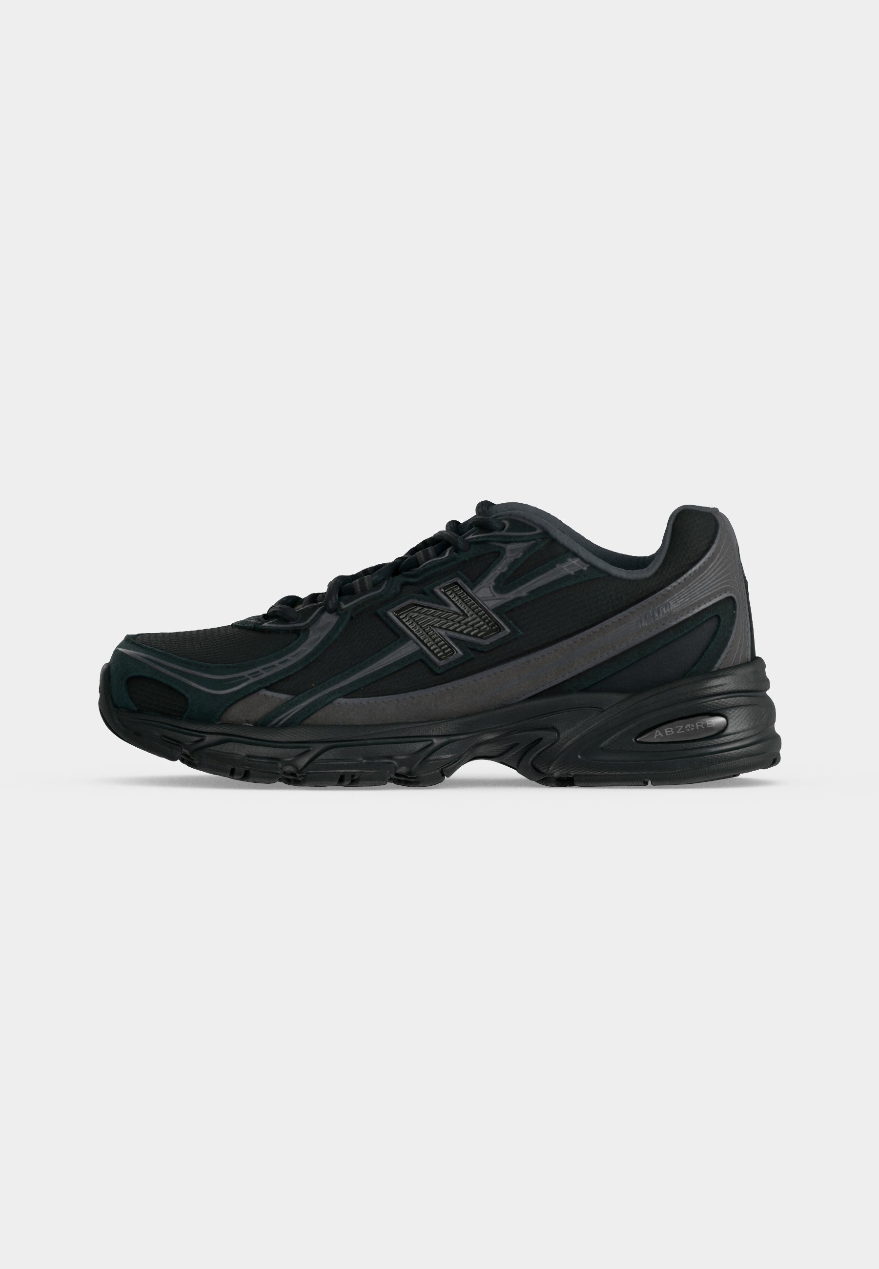 Zapatilla de running New Balance negra y gris oscuro con cierre de cordones y suela acolchada, mostrada de perfil sobre un fondo claro y liso.