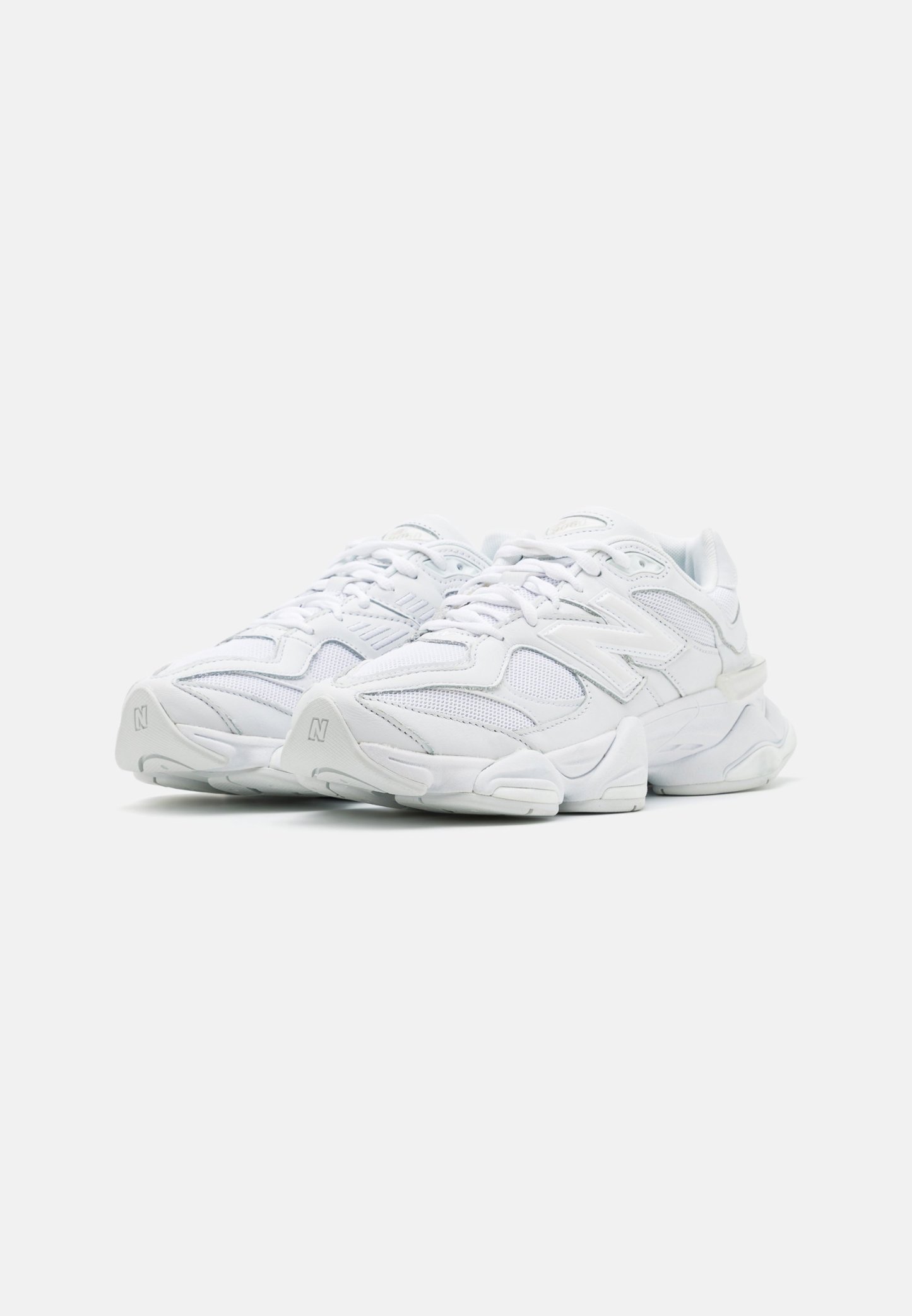 Zapatillas deportivas blancas con parte superior de malla, diseño en capas, suela acolchada y acentos texturizados. Cuentan con cordones y un logo en el costado.
