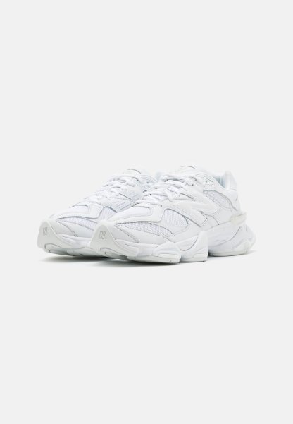 Zapatillas deportivas blancas con parte superior de malla, diseño en capas, suela acolchada y acentos texturizados. Cuentan con cordones y un logo en el costado.