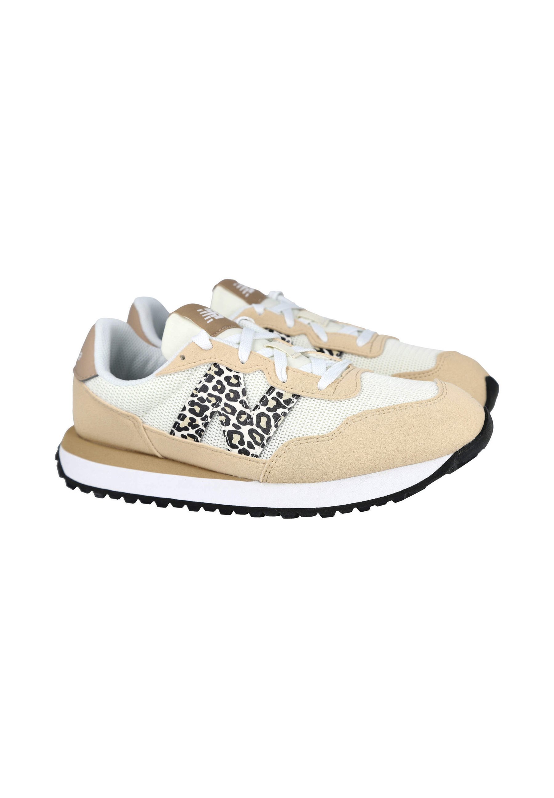 Par de zapatillas beige y blancas con el logo "N" con estampado de leopardo en blanco y negro en los laterales y cordones blancos, mostradas sobre un fondo blanco.