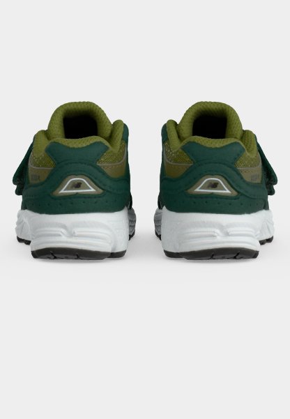 Par de zapatillas deportivas verdes y oliva con suelas blancas vistas desde atrás sobre un fondo claro y liso.