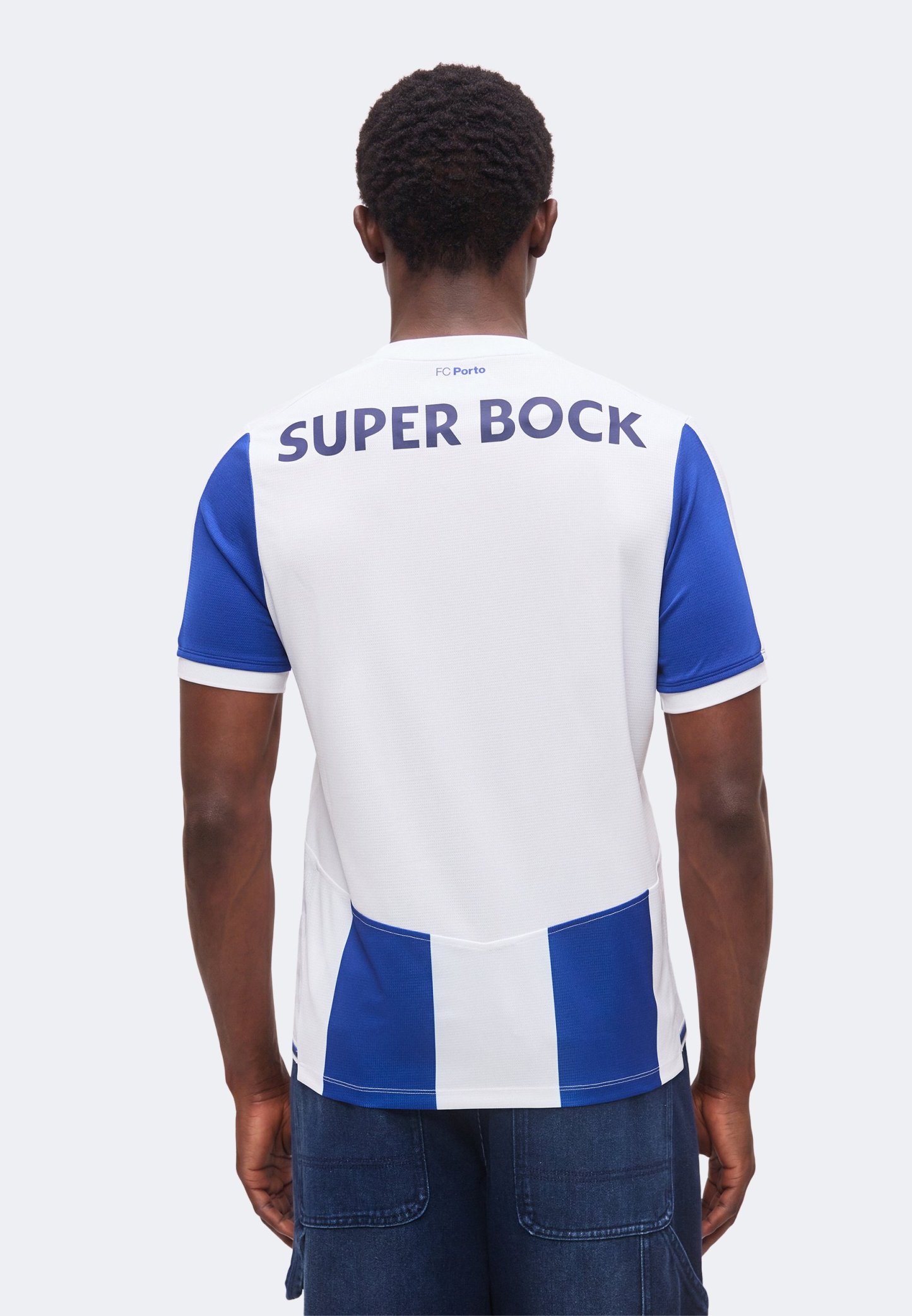 Persona vista desde atrás vistiendo una camiseta de fútbol blanca y azul del FC Porto con el texto "Super Bock" en la parte superior de la espalda.