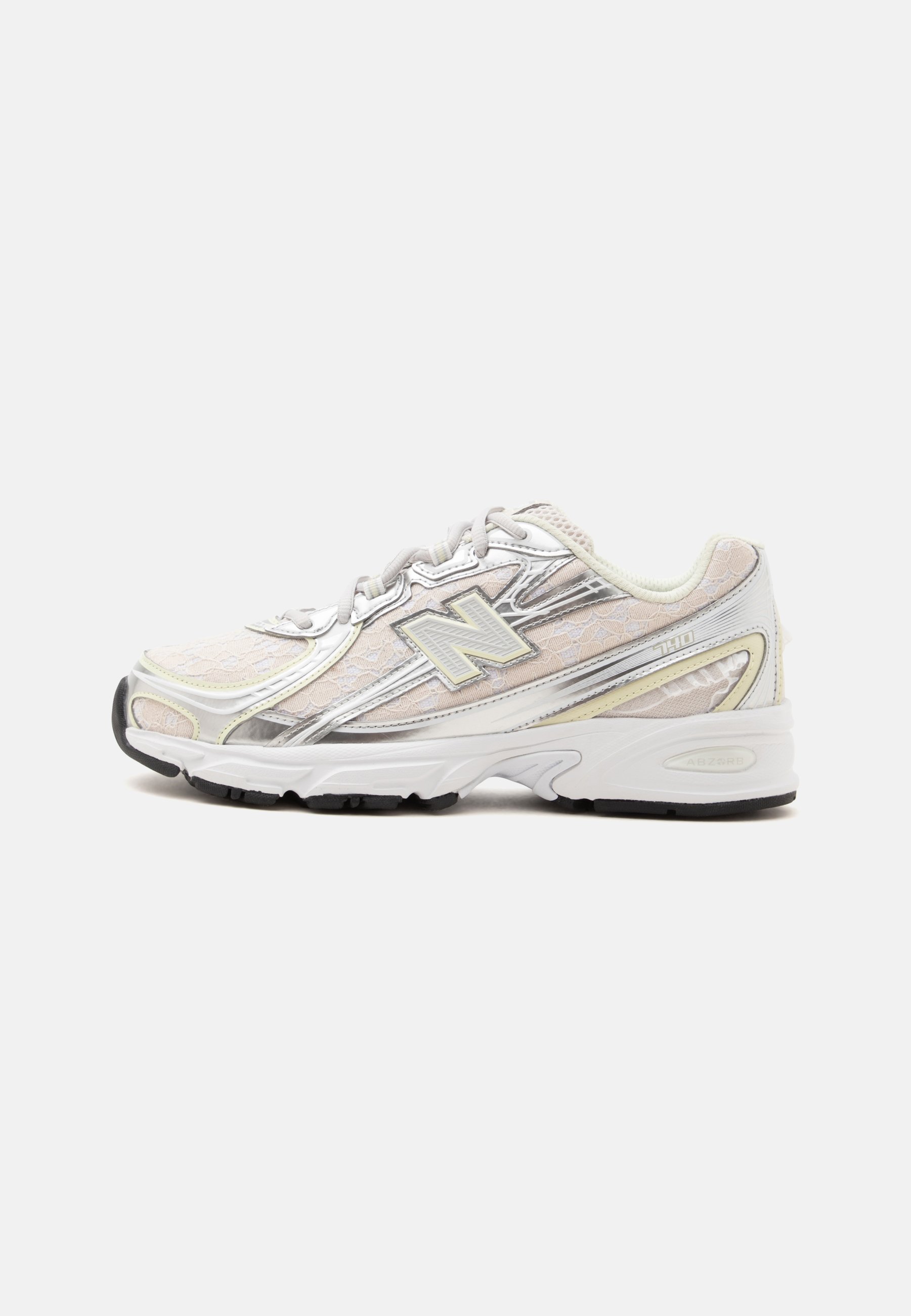 Zapatilla de running New Balance blanca y plateada con cordones delanteros, tejido de malla y suela de goma negra vista desde un lateral.