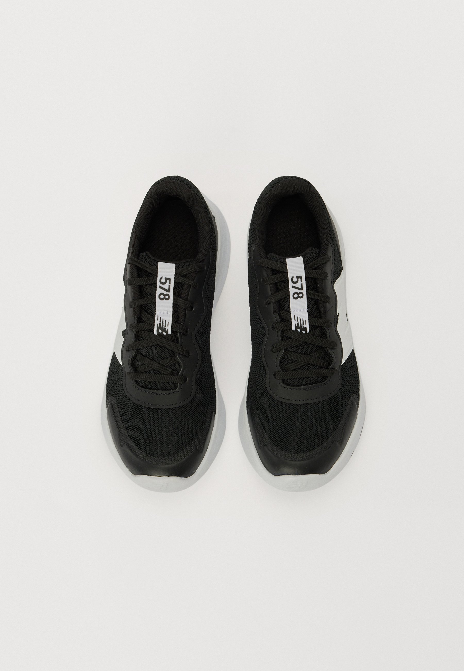 Zapatillas deportivas negras con tejido de malla, cordones negros y acentos blancos. Presenta una suela de goma texturizada y una etiqueta prominente que dice "578".