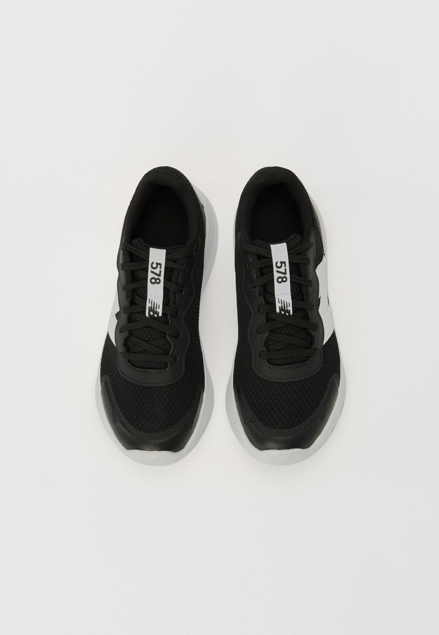 Zapatillas deportivas negras con tejido de malla, cordones negros y acentos blancos. Presenta una suela de goma texturizada y una etiqueta prominente que dice "578".