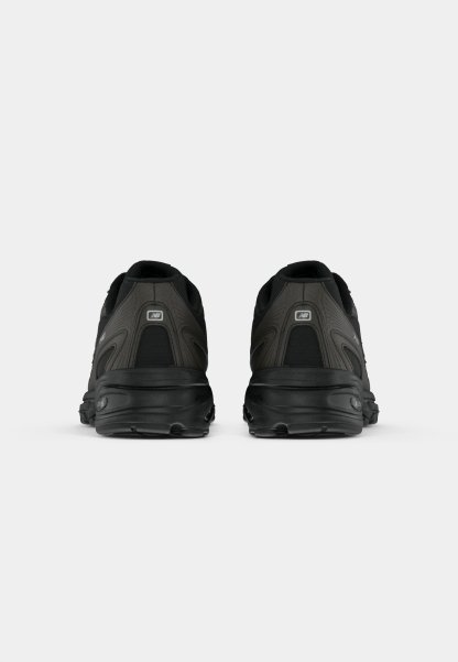 Zapatillas deportivas negras con un upper texturizado, cuello acolchado y suela amortiguada. Presentan un detalle de logo en el talón y líneas de diseño estructuradas.