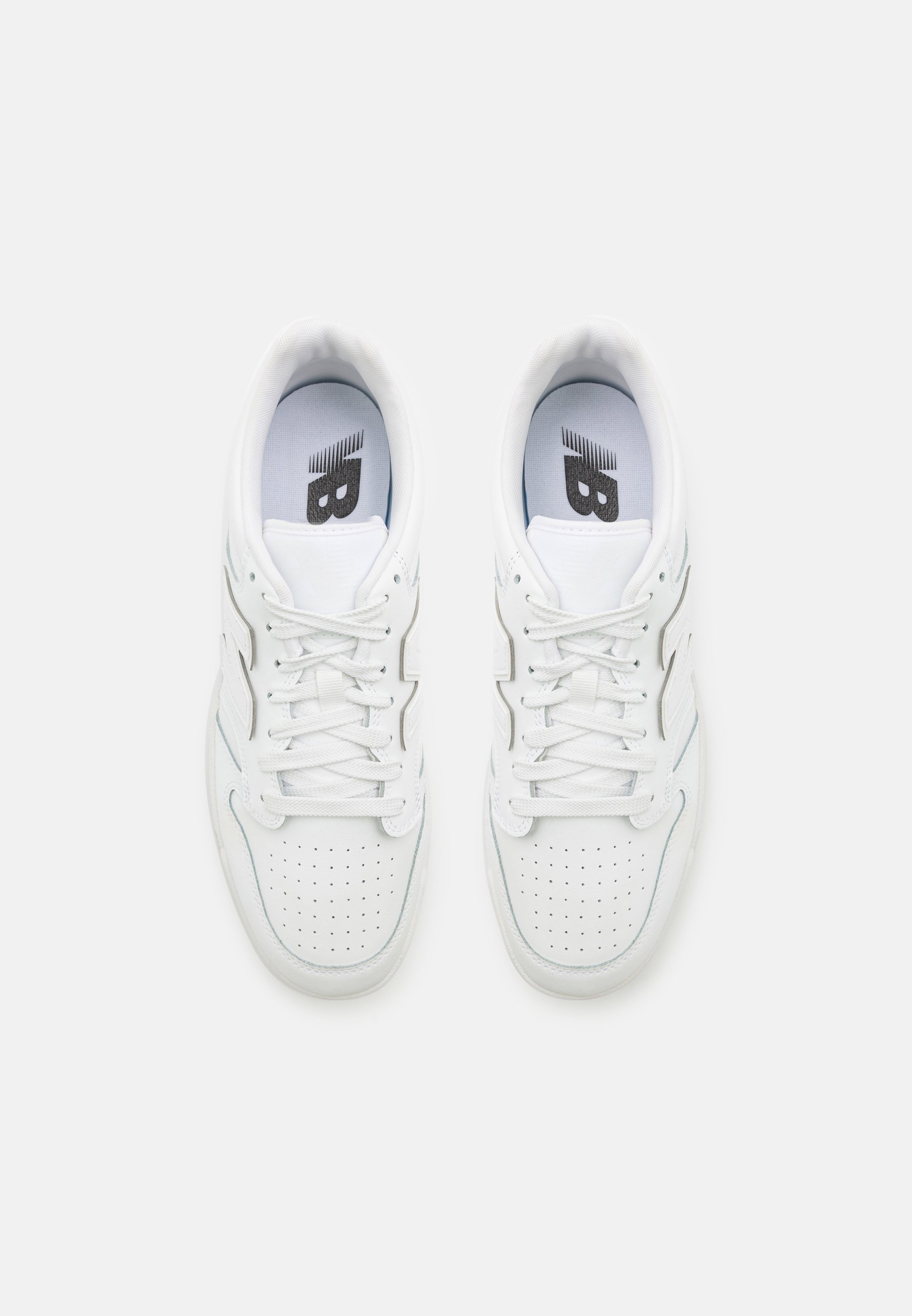 Zapatillas blancas con una parte superior de cuero suave, puntera perforada para transpirabilidad, cordones planos y un logo en la lengüeta. Diseño minimalista.