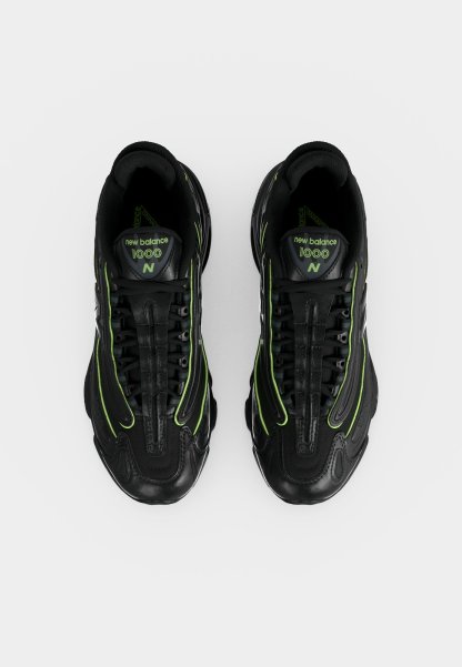 Par de zapatillas negras New Balance 1000 con detalles en verde neón, vista desde arriba sobre un fondo blanco.