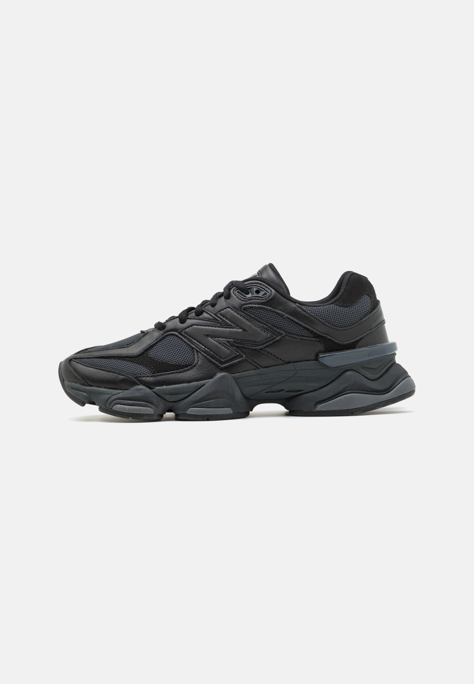 Zapatilla de running negra que presenta una combinación de malla y materiales sintéticos, suela gruesa, diseño curvado y una marca prominente en el costado.