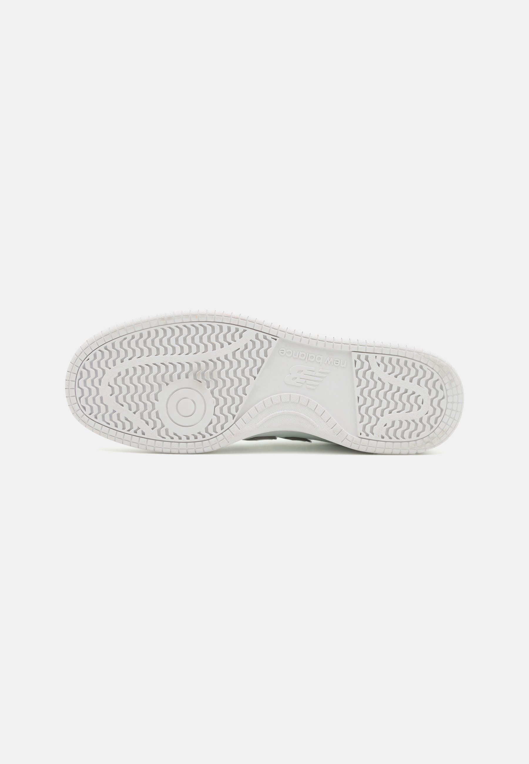 Suela de zapatilla de goma blanca con patrones de textura, que presenta un emblema circular y una sutil marca en la entresuela.