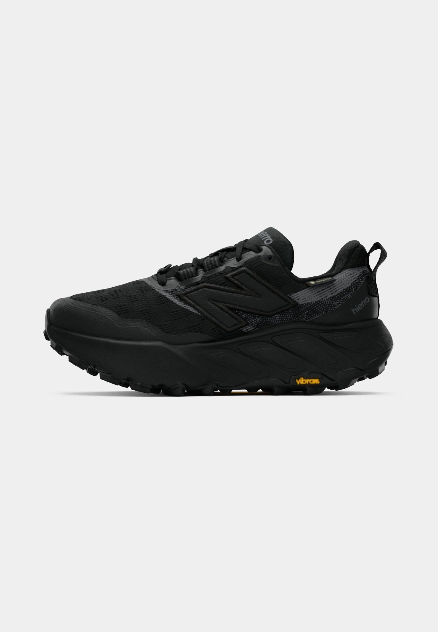 Zapatilla de trail running negra con parte superior de malla transpirable, suela acolchada y suela exterior de goma texturizada. Presenta un logotipo prominente en el costado.
