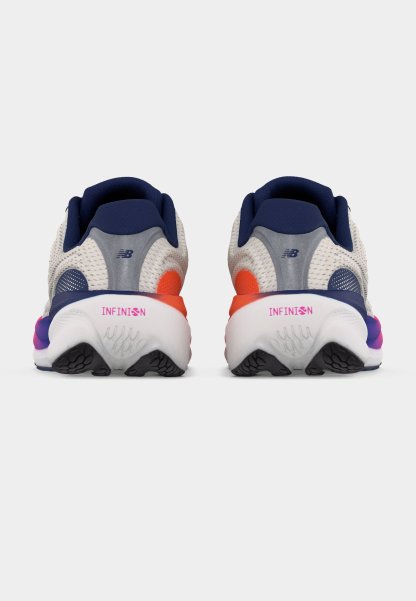 Par de zapatillas de correr blancas y azul marino con detalles en naranja y rosa, vistas desde atrás, mostrando la marca "INFINION" en las medias suelas.