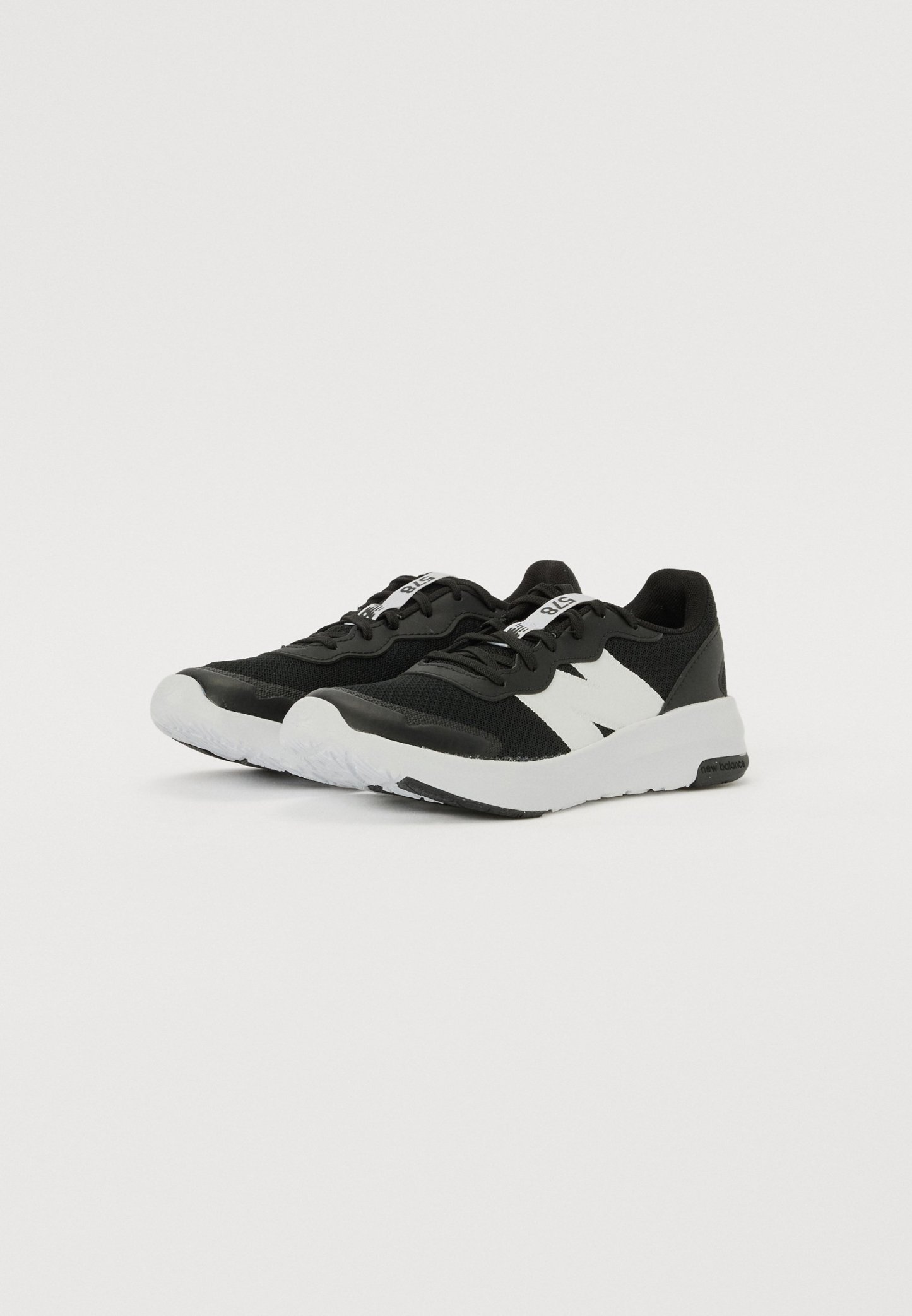 Zapatillas deportivas negras con una parte superior texturizada, acentos blancos y una suela de goma blanca. Incluyen cordones y un logotipo prominente en el lateral.
