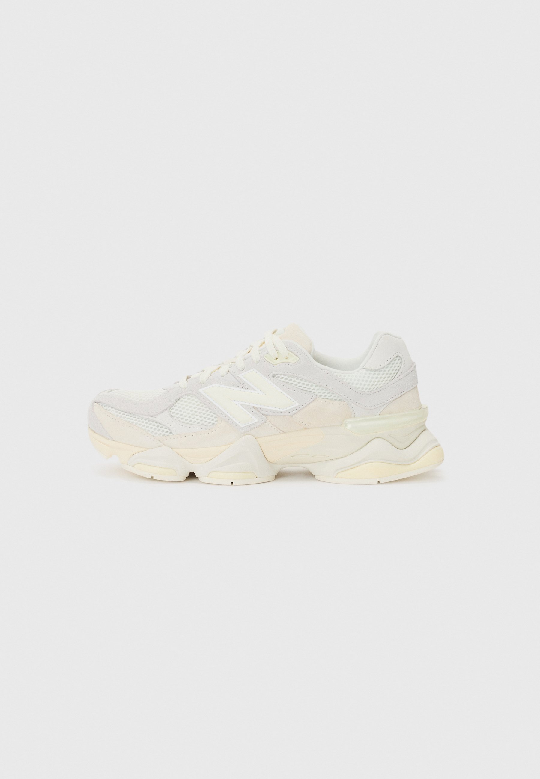 Zapatilla ligera con parte superior de malla y ante en suaves tonos crema, con una suela gruesa y acentos tridimensionales.