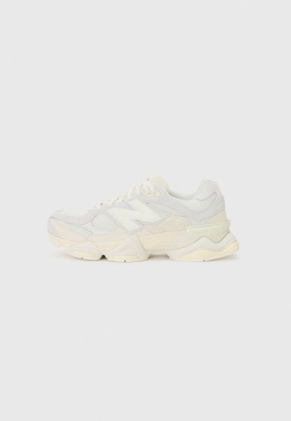 Zapatilla ligera con parte superior de malla y ante en suaves tonos crema, con una suela gruesa y acentos tridimensionales.