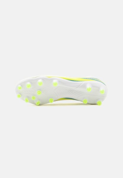 Suela blanca de bota de fútbol con tacos amarillos distribuidos uniformemente para tracción sobre un fondo claro y liso.