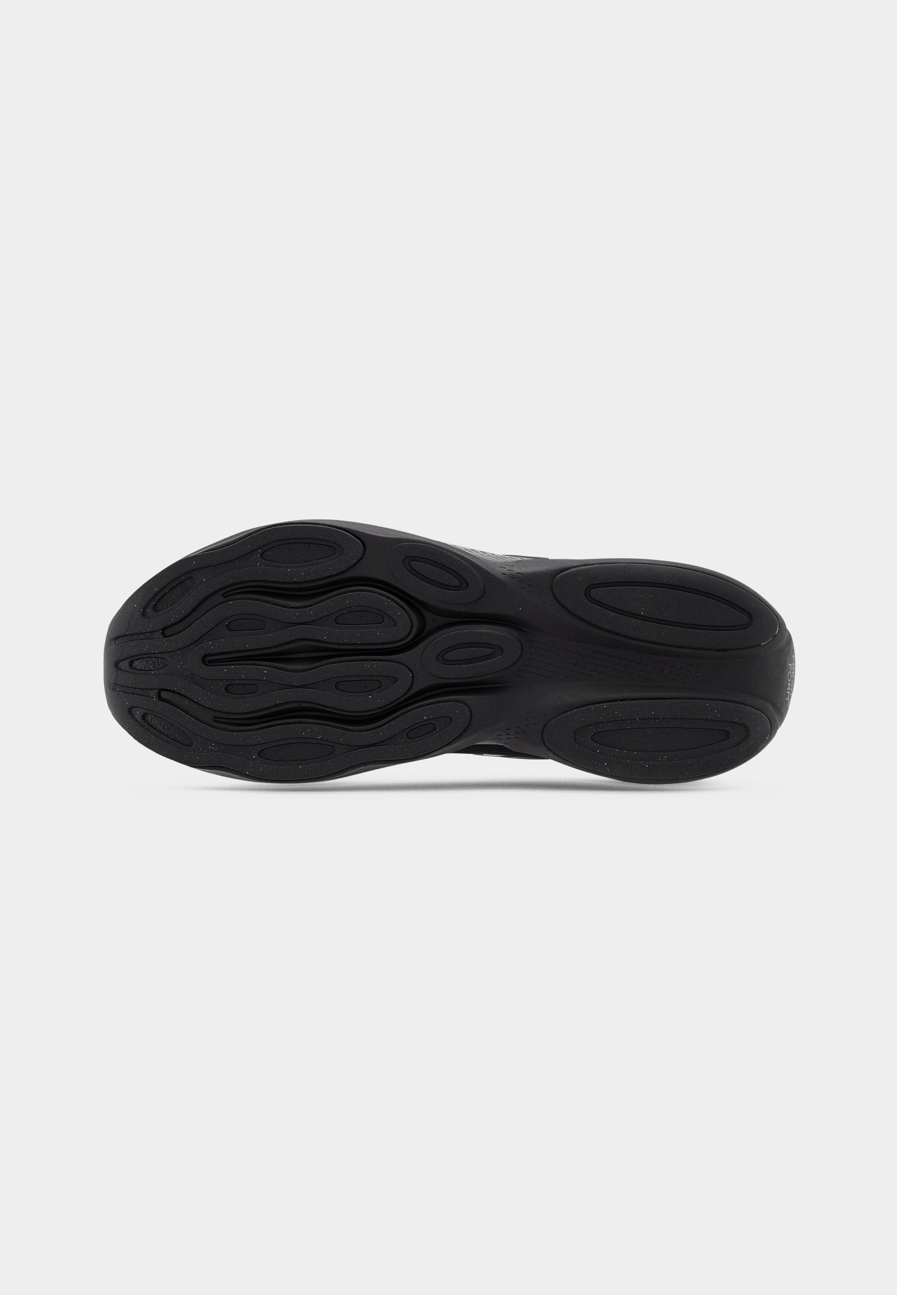 Suela de zapatilla negra con goma texturizada, que presenta un patrón intrincado de ovales y ondas para agarre y estabilidad.