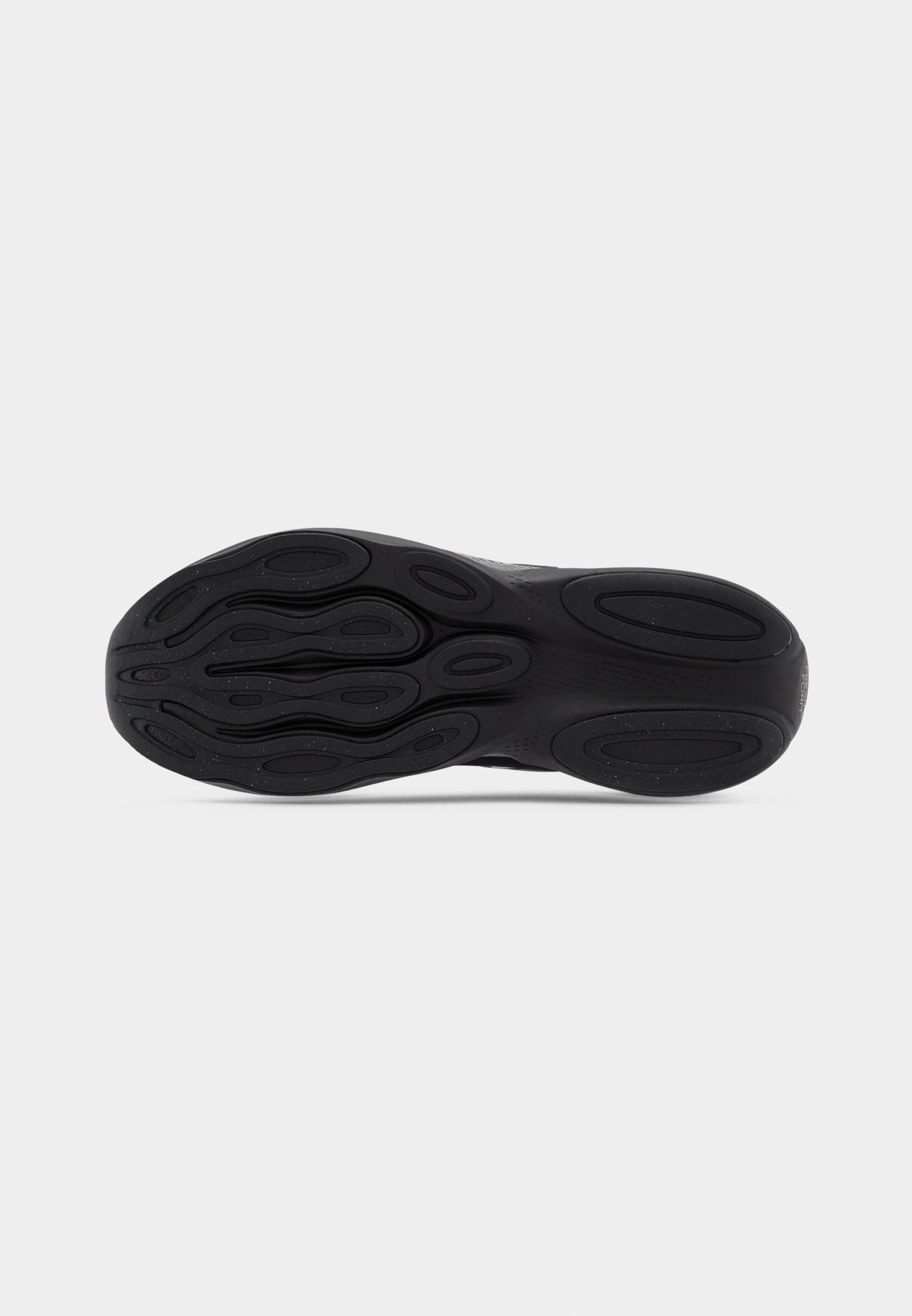 Suela de zapatilla negra con goma texturizada, que presenta un patrón intrincado de ovales y ondas para agarre y estabilidad.