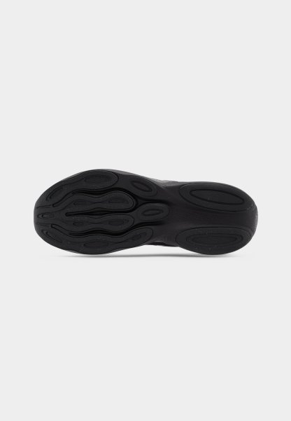 Suela de zapatilla negra con goma texturizada, que presenta un patrón intrincado de ovales y ondas para agarre y estabilidad.