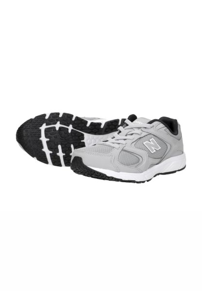 Par de zapatillas de correr New Balance grises con suelas de goma negras y blancas, parte superior de malla y sintética, y cierre de cordones.