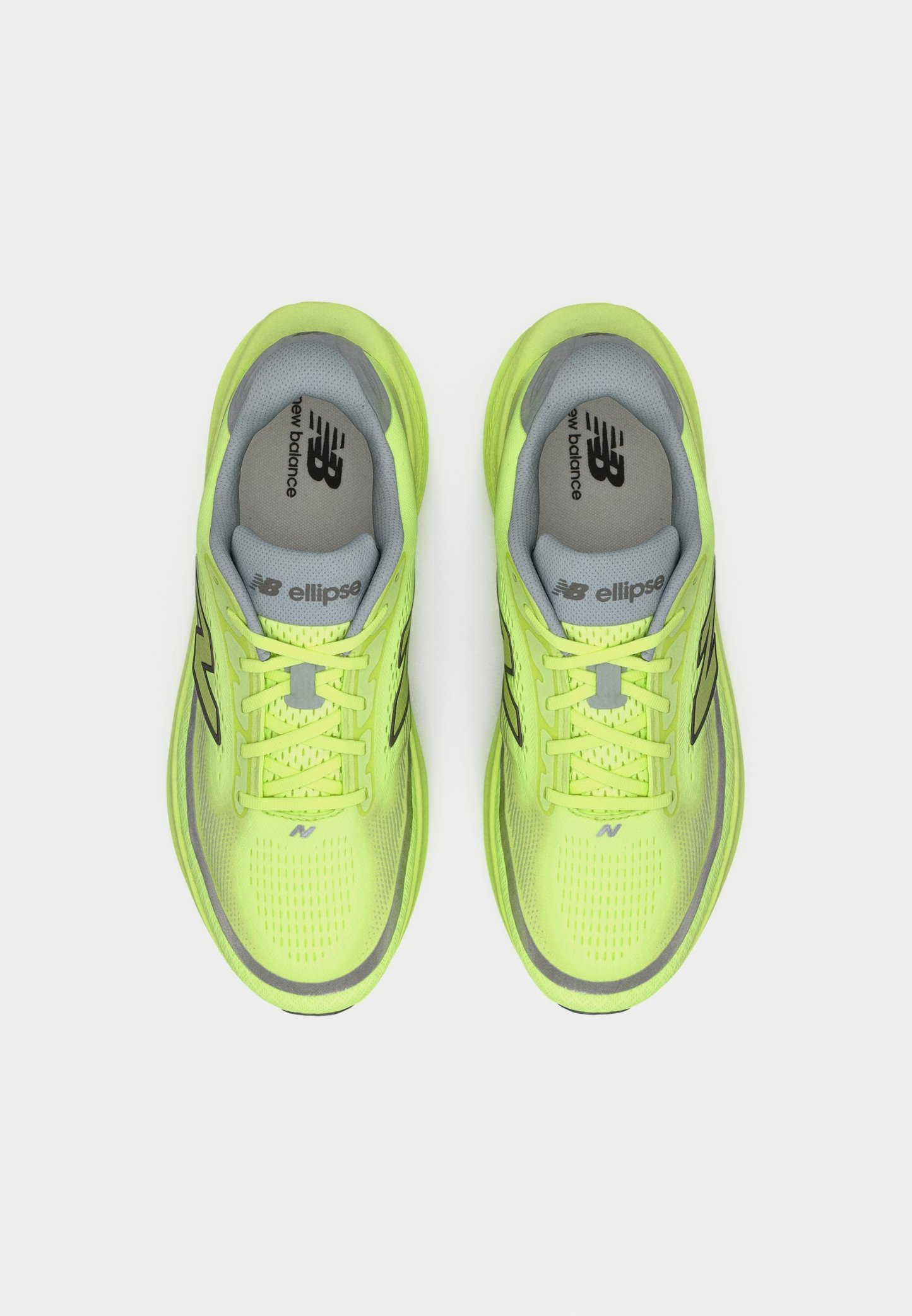 Par de zapatillas de correr New Balance en un brillante color verde amarillo, con plantillas y cordones grises, vistas desde arriba sobre un fondo blanco.