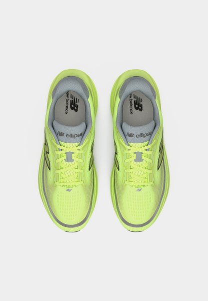 Par de zapatillas de correr New Balance en un brillante color verde amarillo, con plantillas y cordones grises, vistas desde arriba sobre un fondo blanco.
