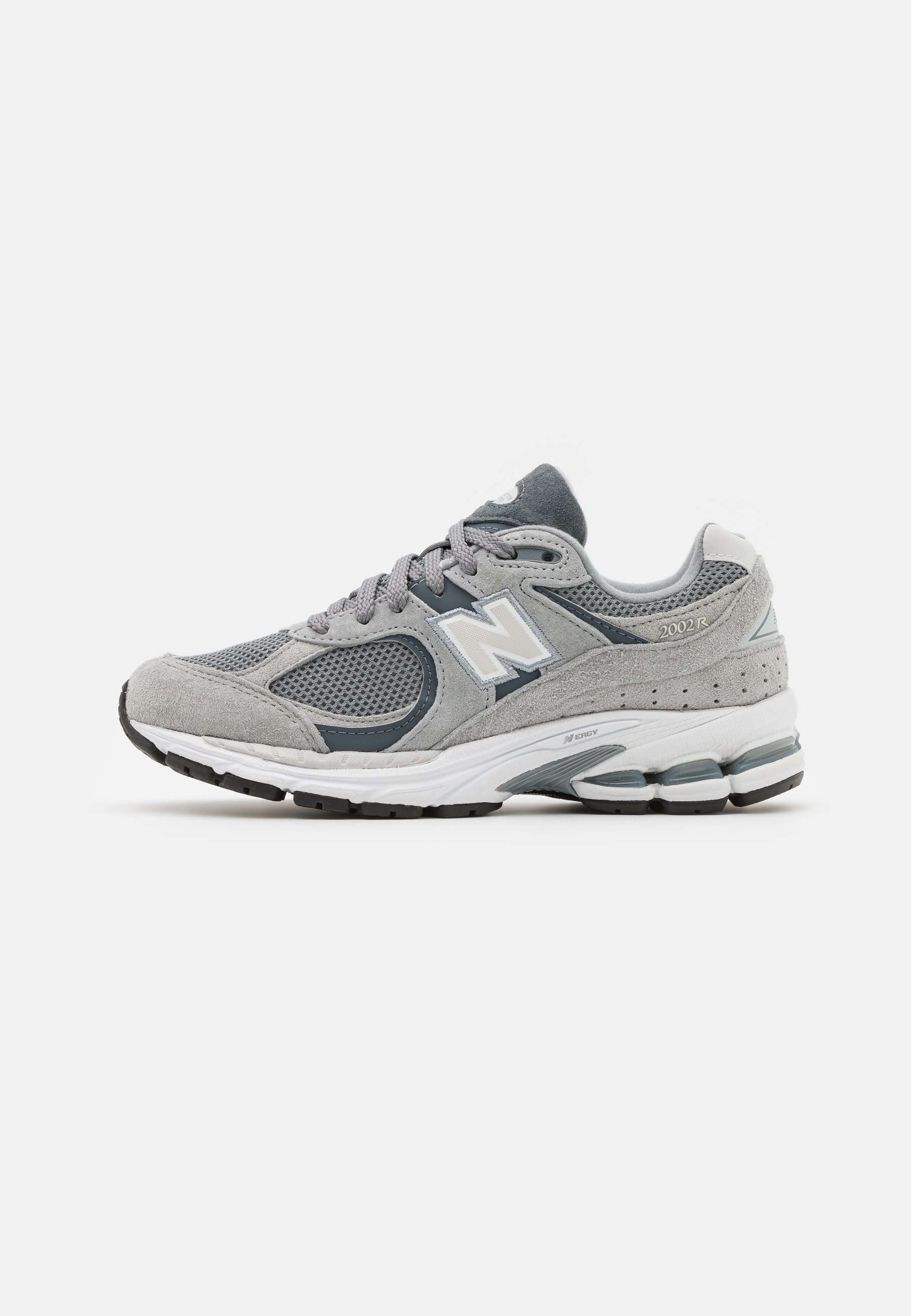 Zapatilla gris con materiales de malla y gamuza, que presenta un logo blanco, un cuello acolchado y una suela de goma texturizada. Detalles en un gris más oscuro.