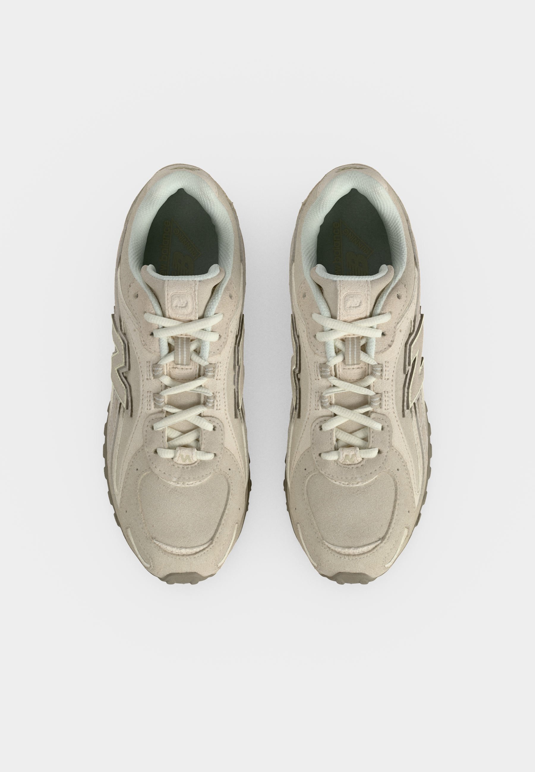 Par de zapatillas deportivas beige con cordones blancos, vistas desde arriba sobre un fondo blanco liso.