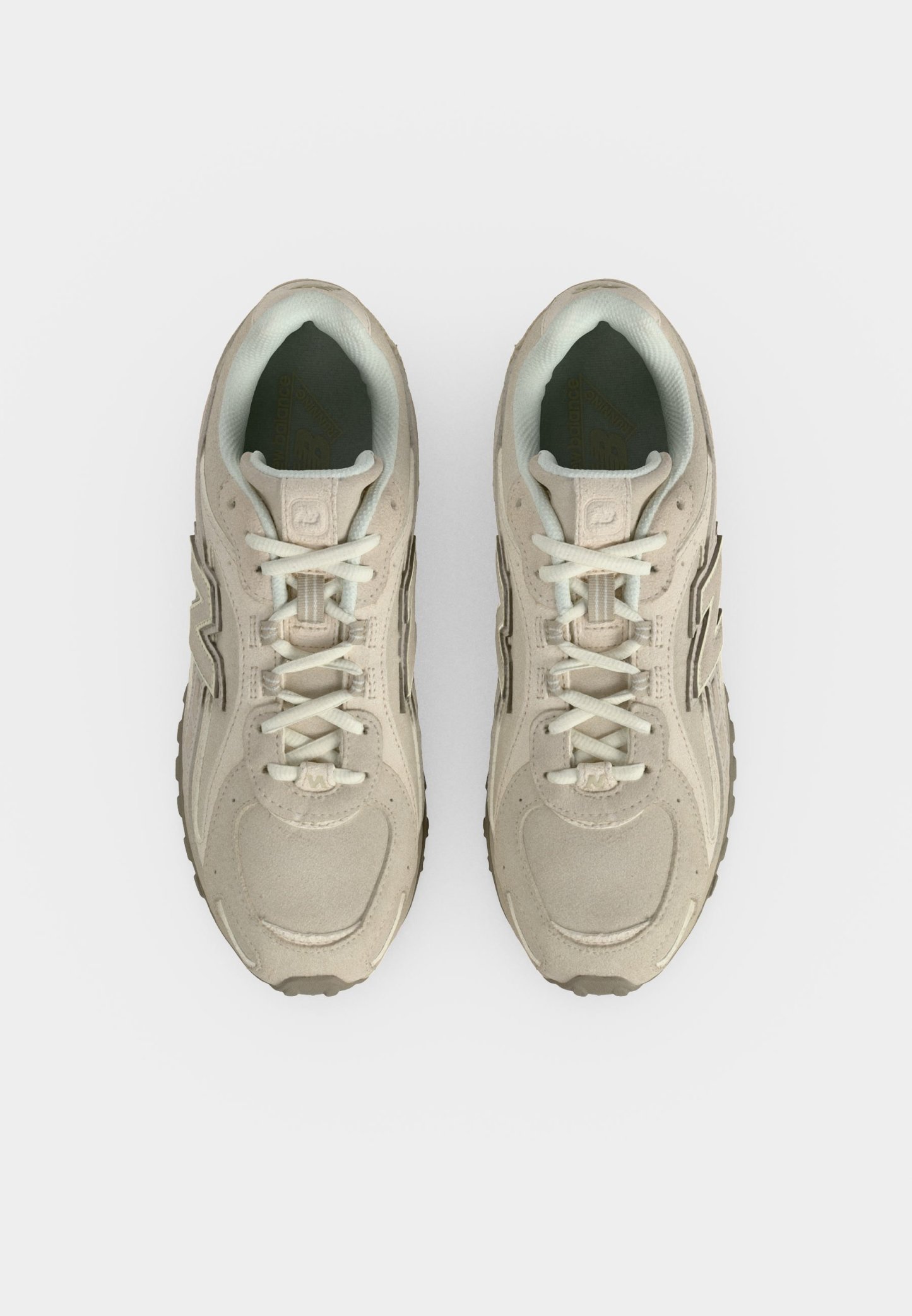 Par de zapatillas deportivas beige con cordones blancos, vistas desde arriba sobre un fondo blanco liso.