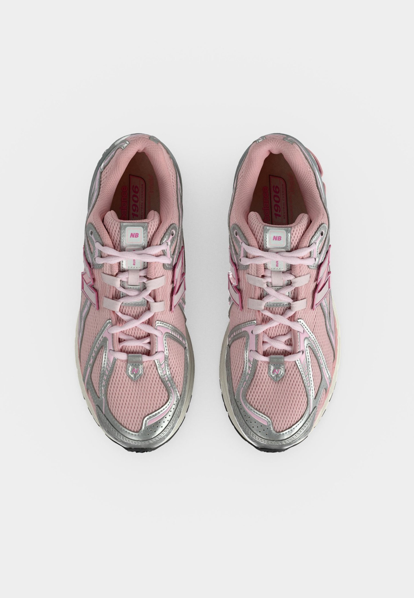 Par de zapatillas para correr New Balance rosas y plateadas con cordones, vista desde arriba sobre un fondo blanco.