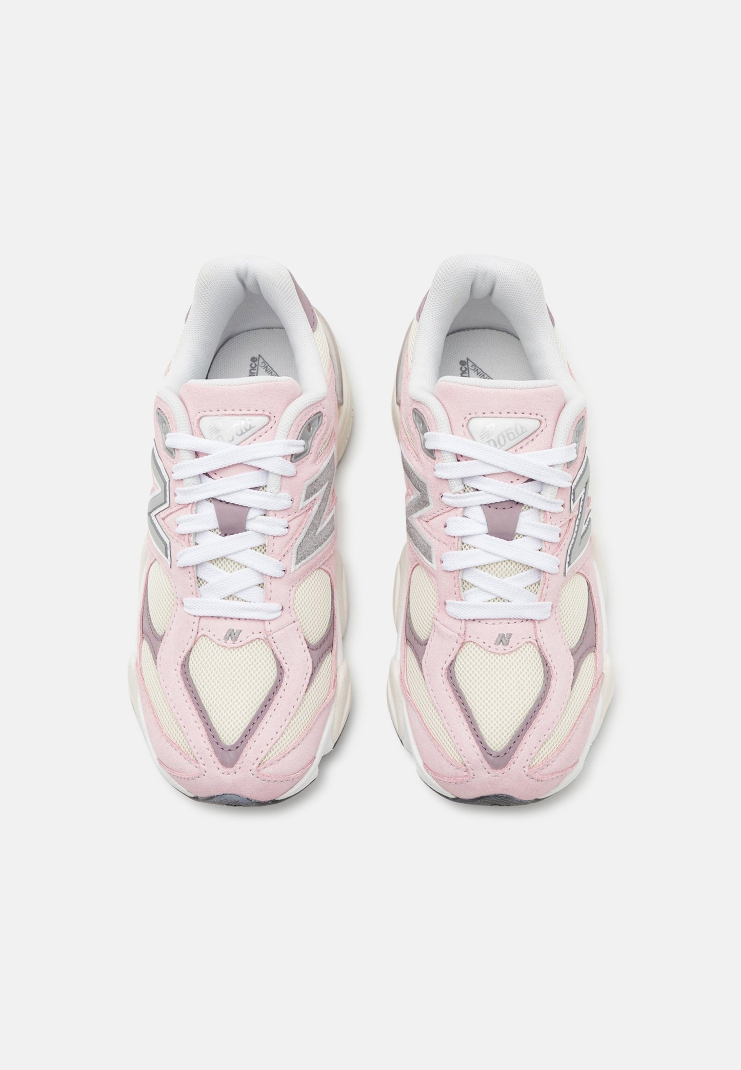 Zapatillas de color rosa claro con acentos en blanco y gris. Los materiales de malla y ante forman la parte superior. Cuenta con cordones blancos y un cuello acolchado.