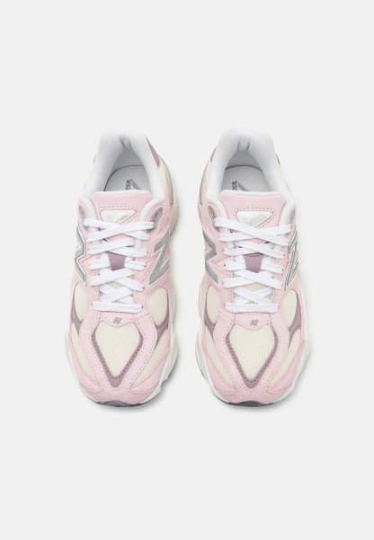 Zapatillas de color rosa claro con acentos en blanco y gris. Los materiales de malla y ante forman la parte superior. Cuenta con cordones blancos y un cuello acolchado.