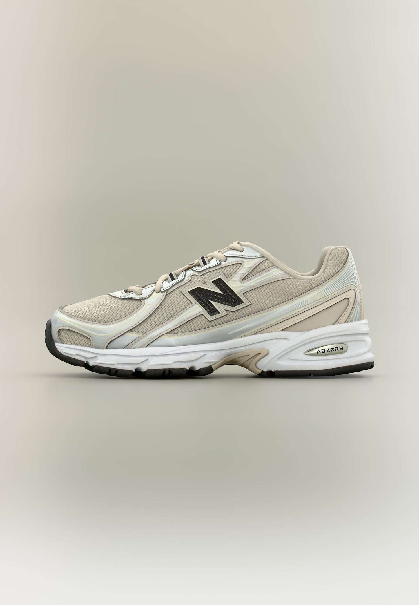 Zapatilla deportiva New Balance beige y blanca con paneles de malla, logo negro en el lateral y suela blanca acolchada con etiqueta de tecnología ABSORB.