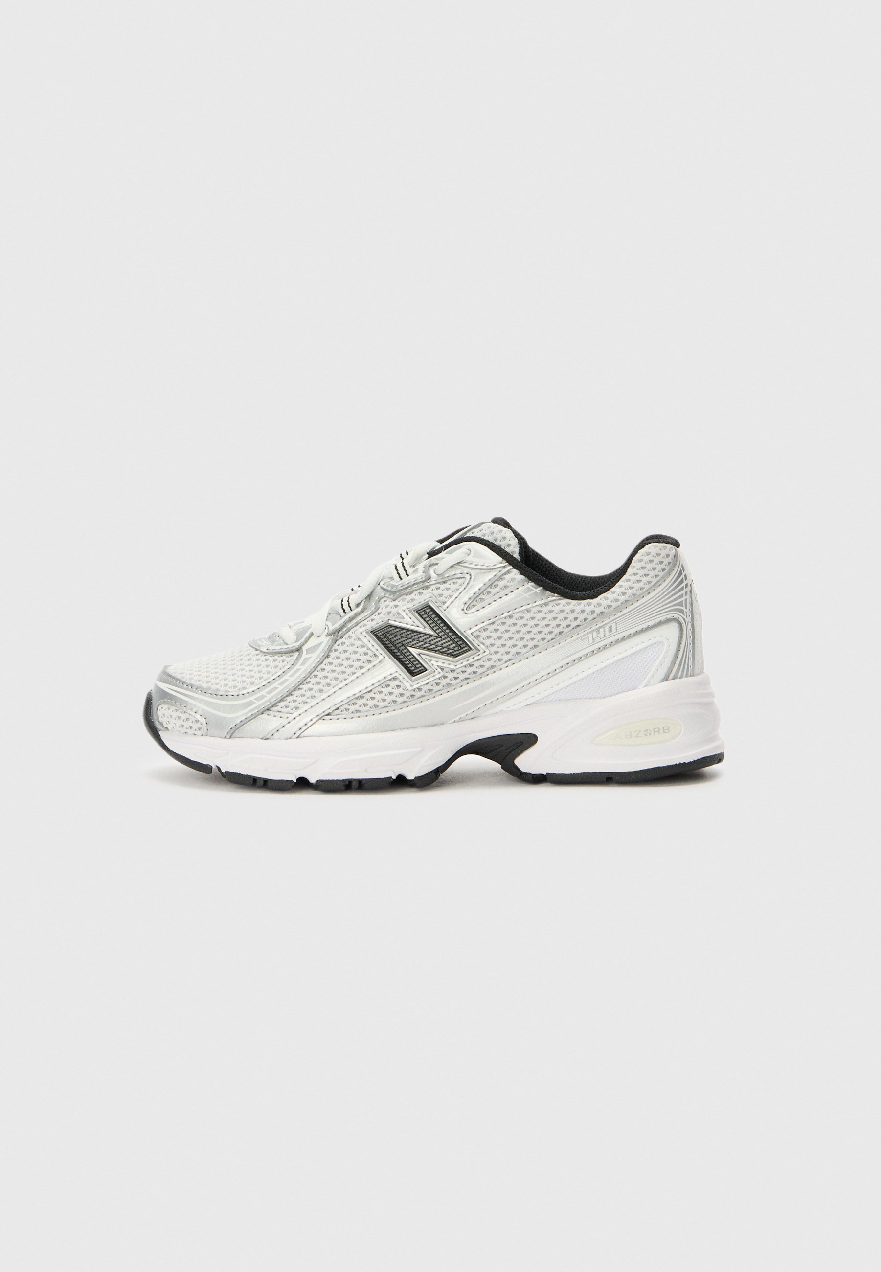 Zapatilla deportiva blanca y gris con empeine de malla, logo negro en el lateral, forro interior negro y suela blanca gruesa con dibujo negro.