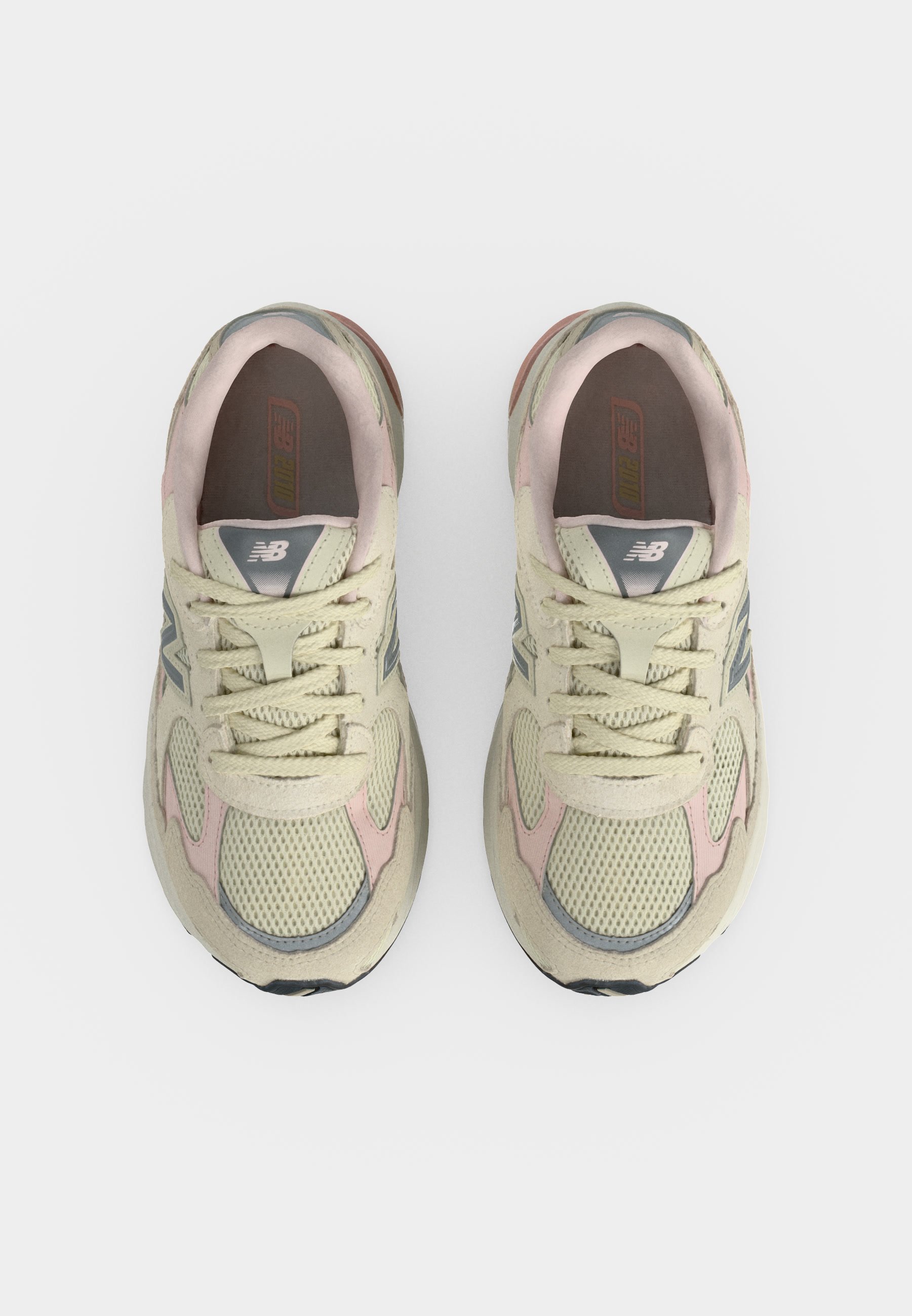 Par de zapatillas de correr New Balance beige y rosa vistas desde arriba sobre un fondo blanco.
