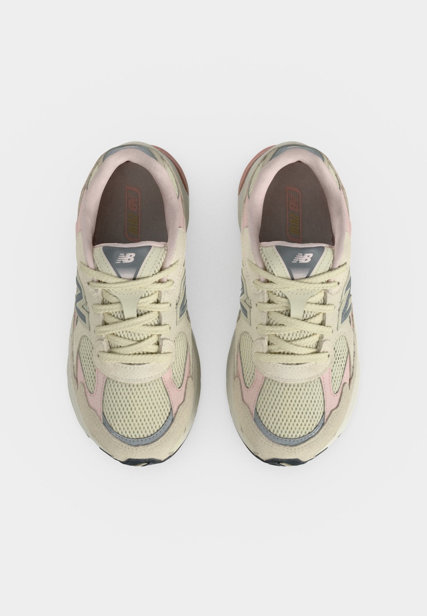 Par de zapatillas de correr New Balance beige y rosa vistas desde arriba sobre un fondo blanco.