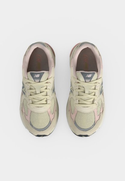 Par de zapatillas de correr New Balance beige y rosa vistas desde arriba sobre un fondo blanco.