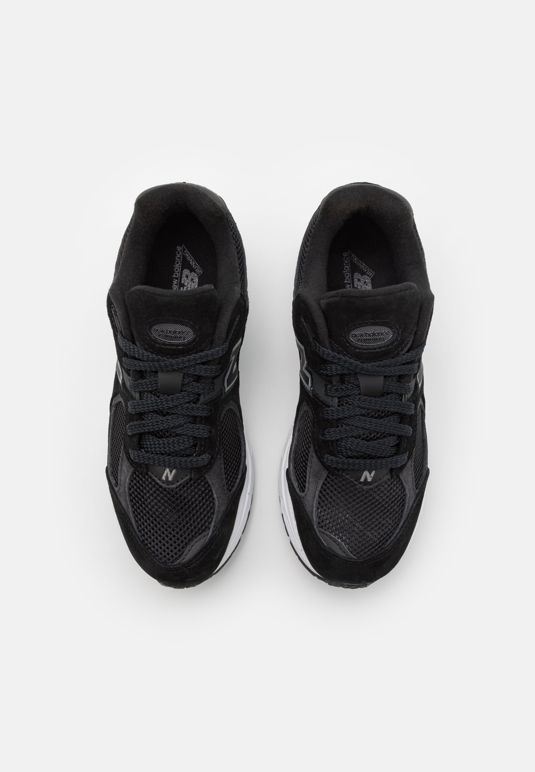 Zapatillas deportivas negras con materiales de malla y ante, que cuentan con una suela acolchada, cordones redondos y un logo en el lateral.